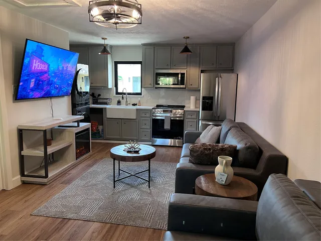 a living room with furniture kitchen view and a fireplace