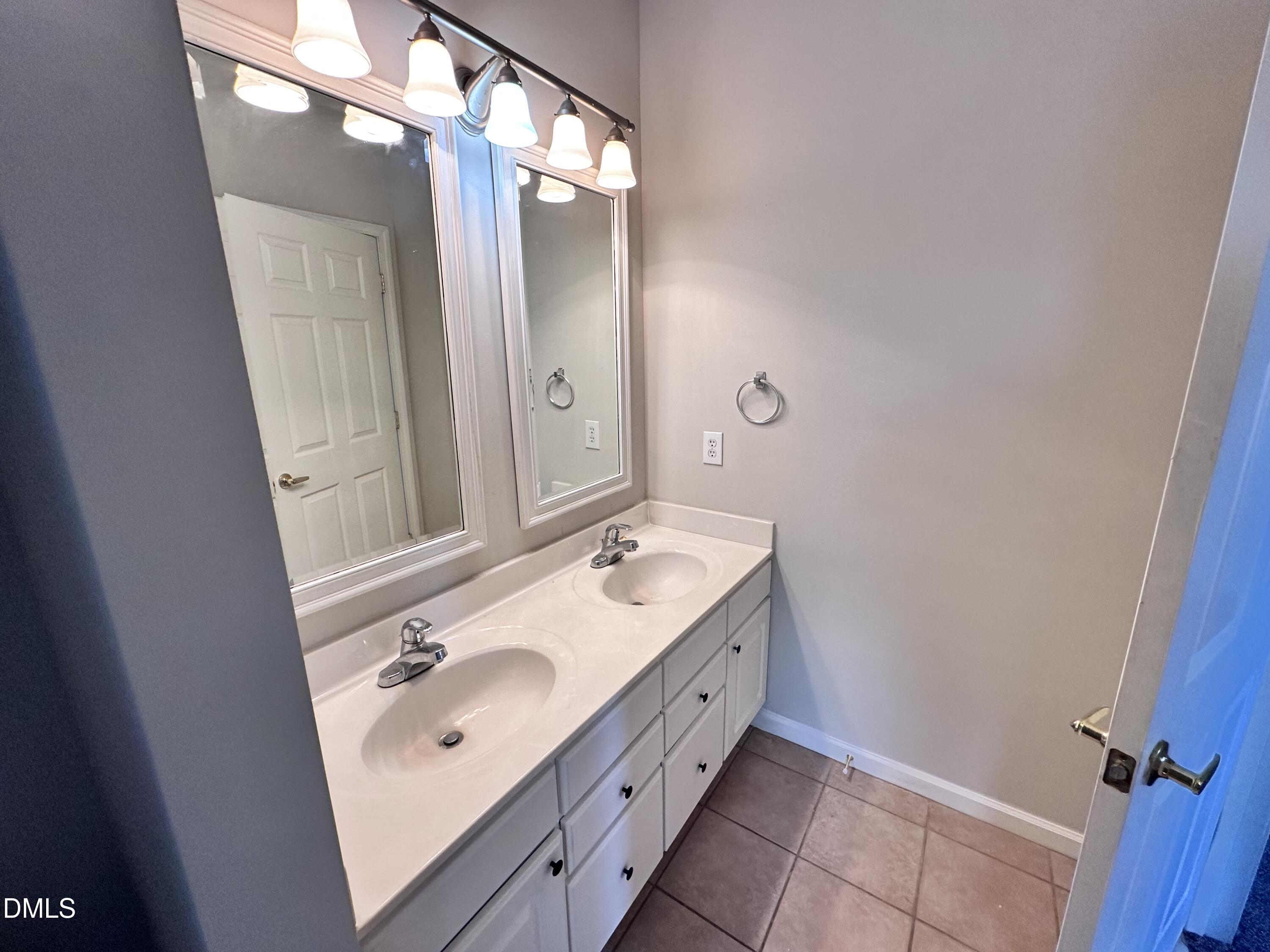 2511 Huntscroft Lane, Unit 203 Raleigh, NC 27617 - Photo 13 of 13 a bathroom with a double vanity sink a mirror and a shower