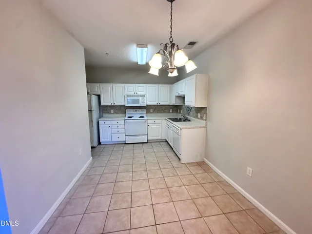 a kitchen with cabinets appliances a sink and a counter top space