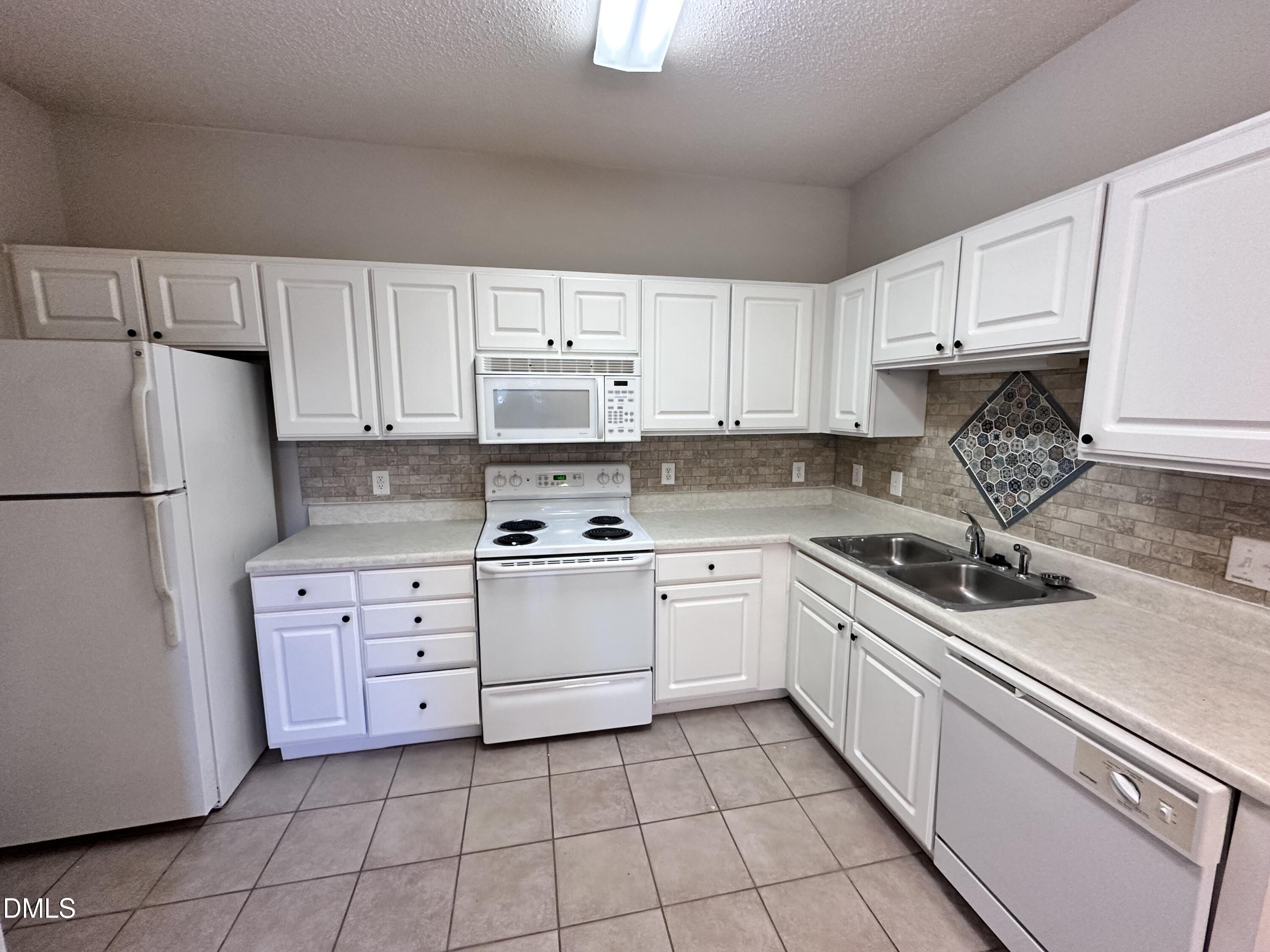 2511 Huntscroft Lane, Unit 203 Raleigh, NC 27617 - Photo 4 of 13 a kitchen with cabinets appliances a sink and a counter top space