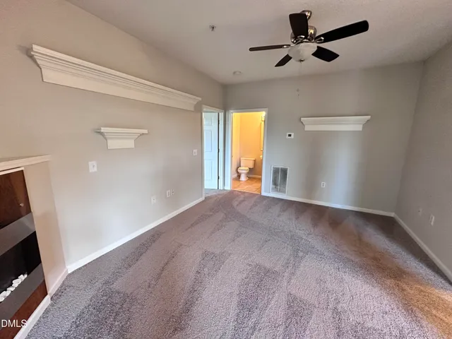 an empty room with windows and chandelier fan