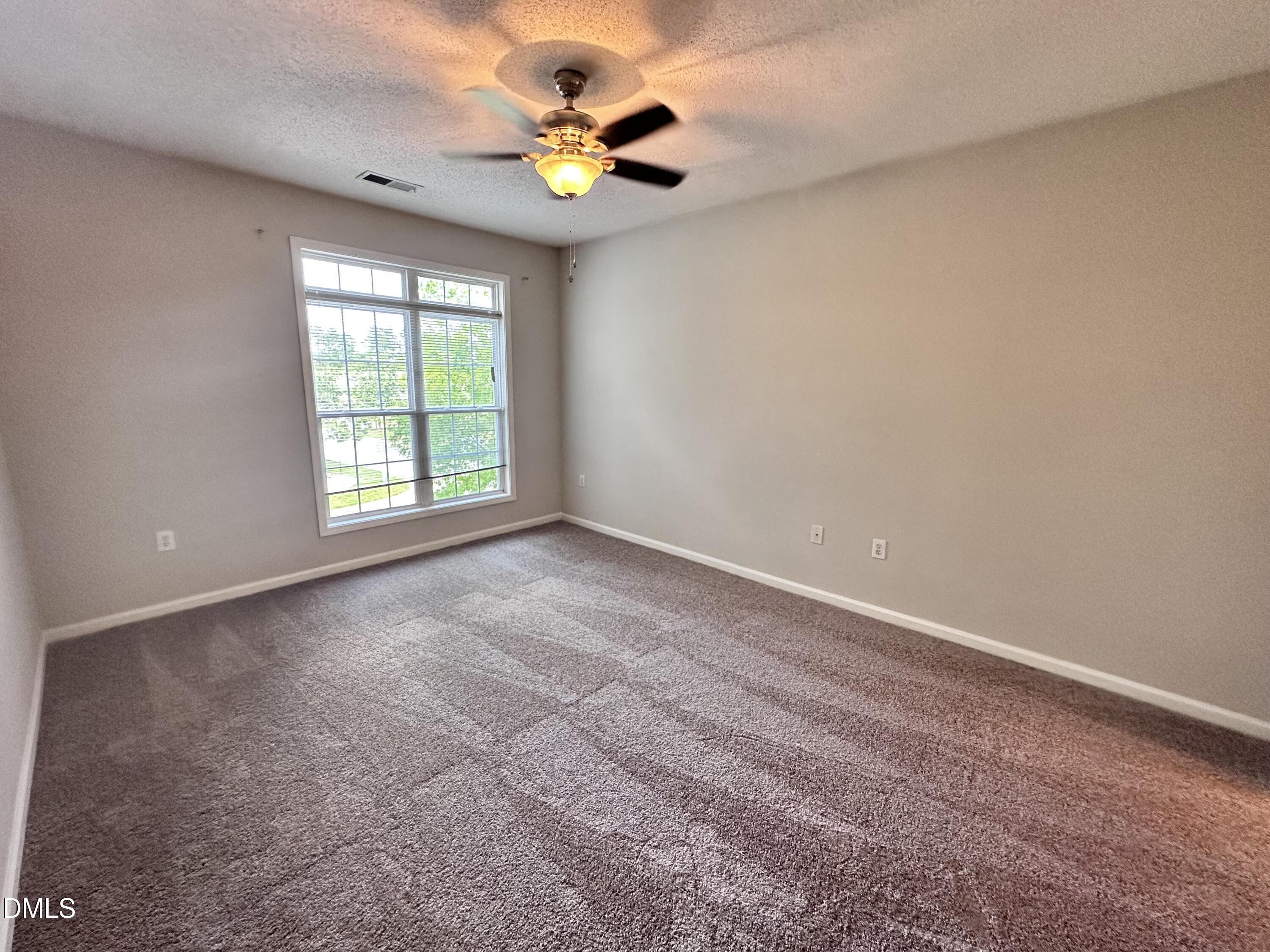 2511 Huntscroft Lane, Unit 203 Raleigh, NC 27617 - Photo 9 of 13 an empty room with windows and chandelier fan