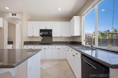 a kitchen with stainless steel appliances granite countertop a sink stove and cabinets