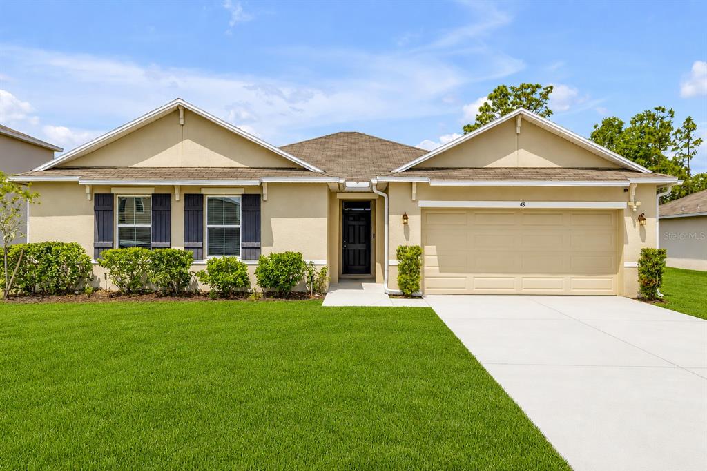 48 Hickory Loop Ocala, FL 34472 - Photo 2 of 52 a front view of a house with a yard and garage