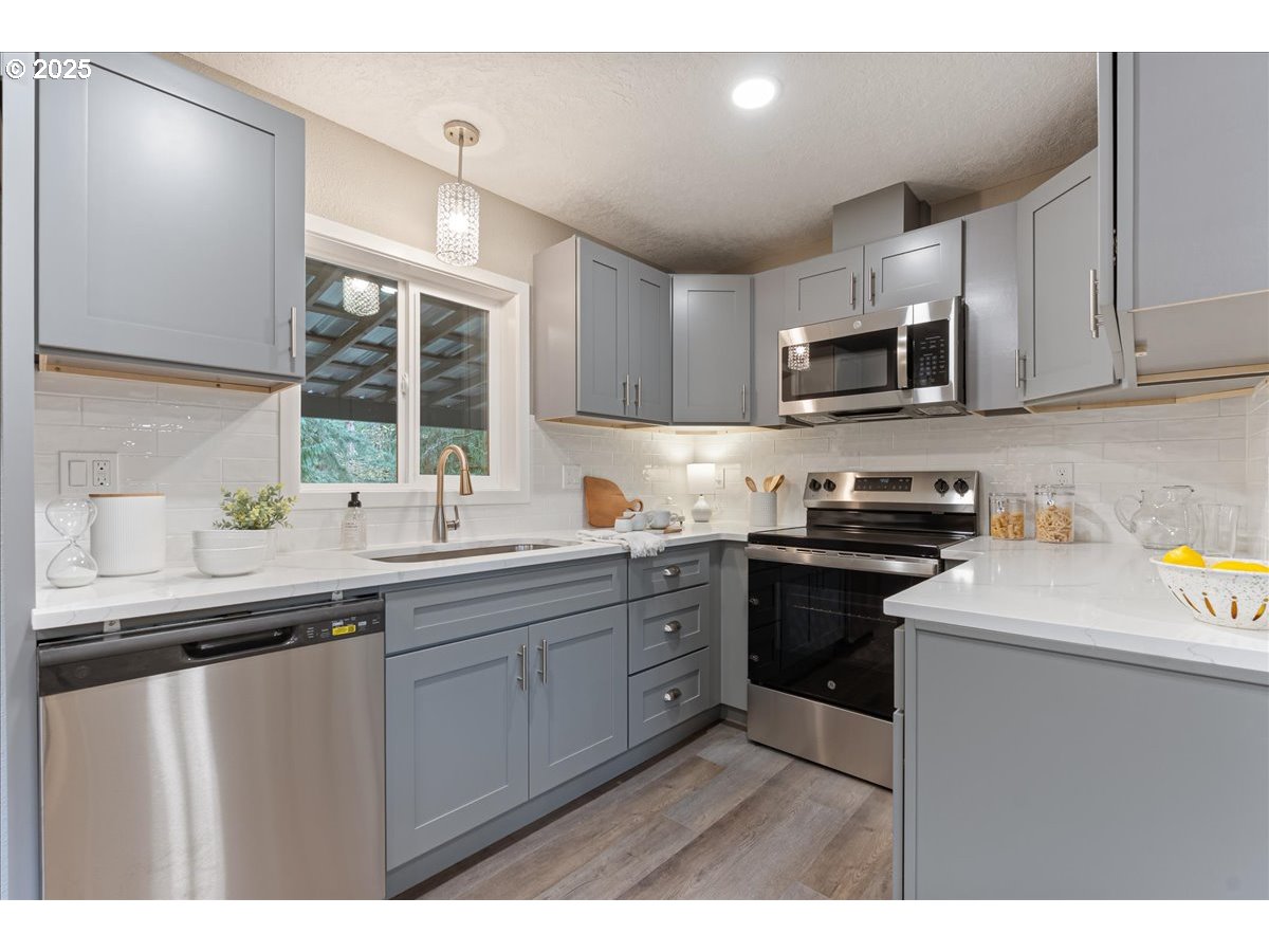 32900 Southeast Colorado Road Sandy, OR 97055 - Photo 11 of 38 a kitchen with stainless steel appliances a sink a stove a microwave a sink and cabinets