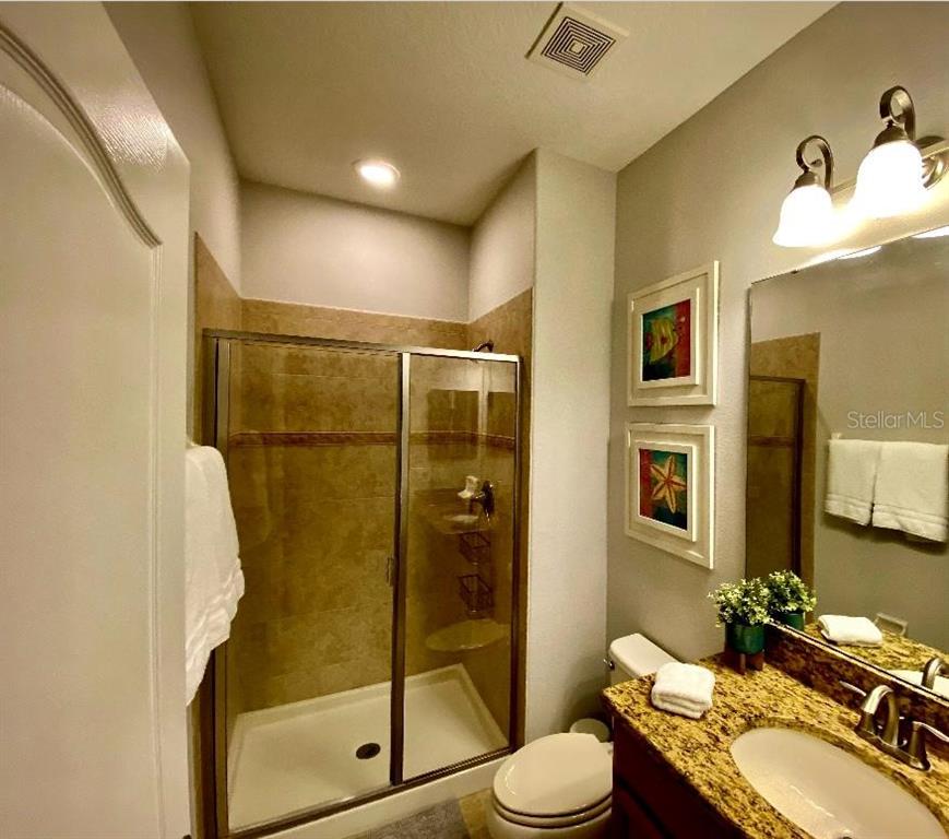 8979 California Palm Road Kissimmee, FL 34747 - Photo 11 of 33 a bathroom with a granite countertop sink toilet and shower