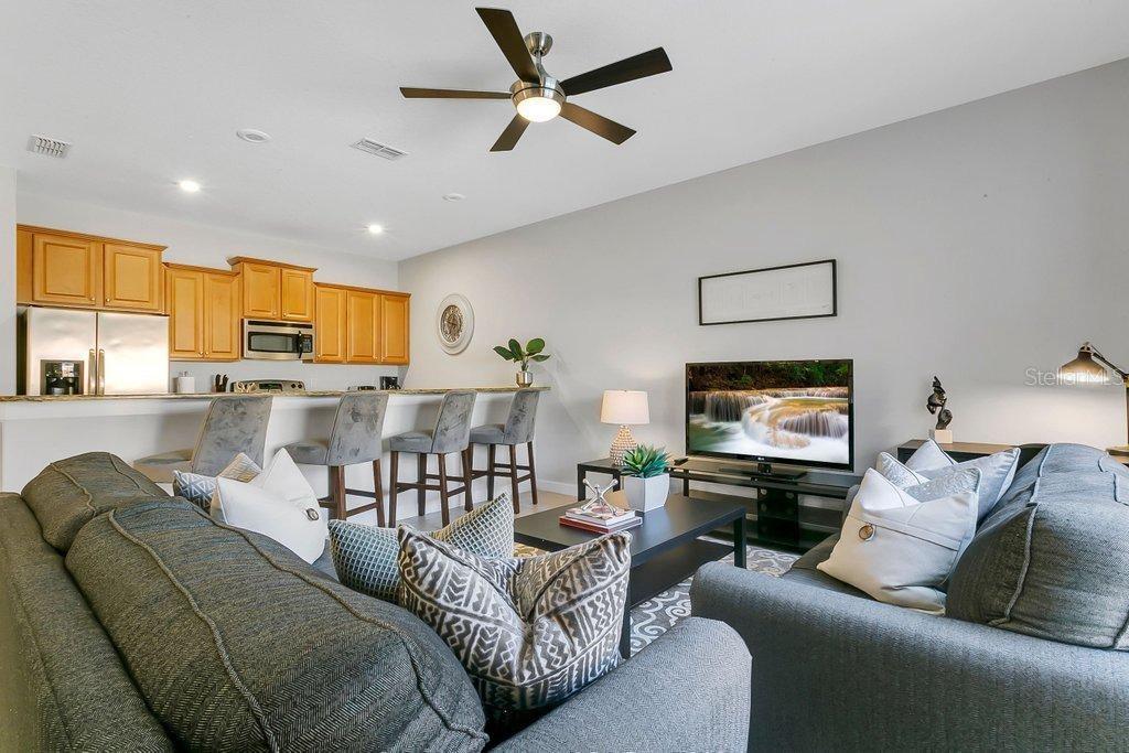 8979 California Palm Road Kissimmee, FL 34747 - Photo 3 of 33 a living room with furniture kitchen view and a flat screen tv
