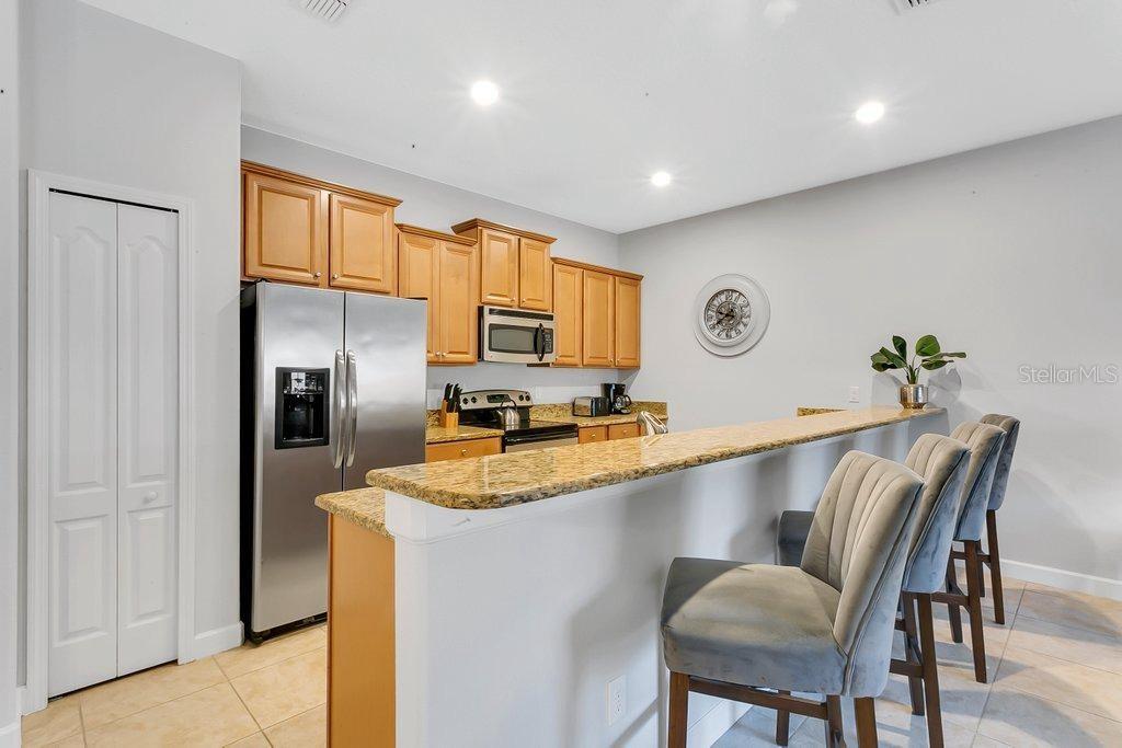 8979 California Palm Road Kissimmee, FL 34747 - Photo 4 of 33 a kitchen with granite countertop a refrigerator stove microwave and sink
