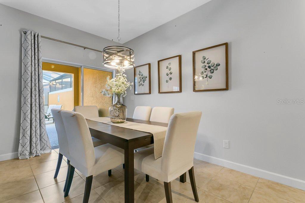 8979 California Palm Road Kissimmee, FL 34747 - Photo 6 of 33 a dining room with furniture a chandelier and window