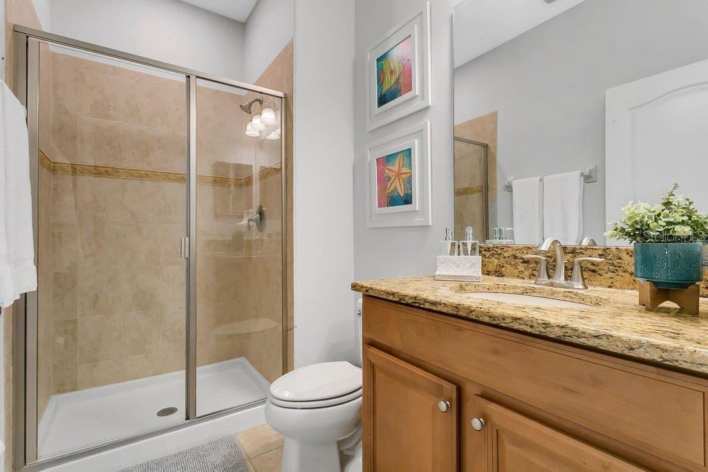 8979 California Palm Road Kissimmee, FL 34747 - Photo 8 of 33 a bathroom with a granite countertop sink a toilet and shower