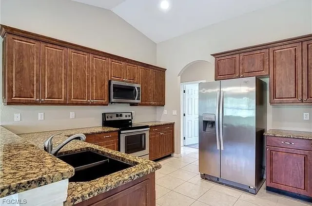 a kitchen with granite countertop stainless steel appliances and wooden cabinets