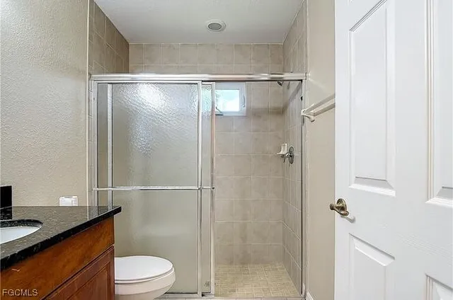 a bathroom with a shower a toilet and a sink