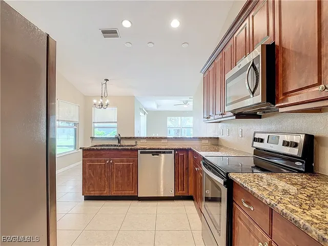 a kitchen with stainless steel appliances granite countertop a sink and a stove