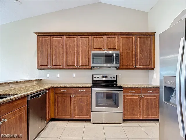 a kitchen with stainless steel appliances granite countertop a stove top oven microwave and cabinets