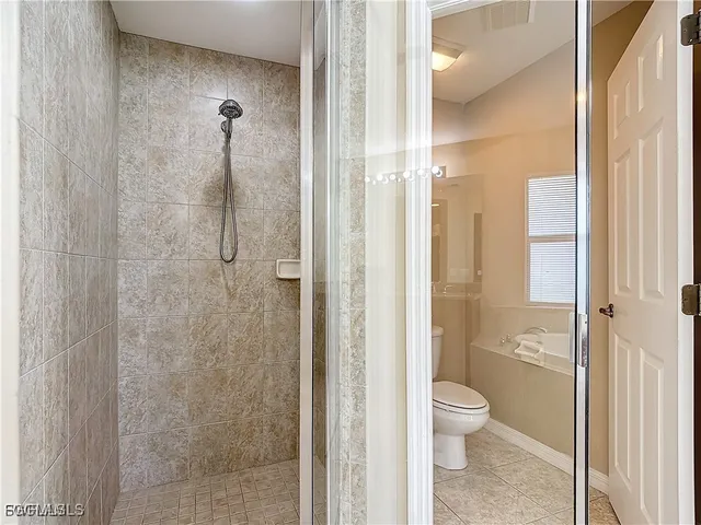 a bathroom with a granite countertop toilet a sink and shower
