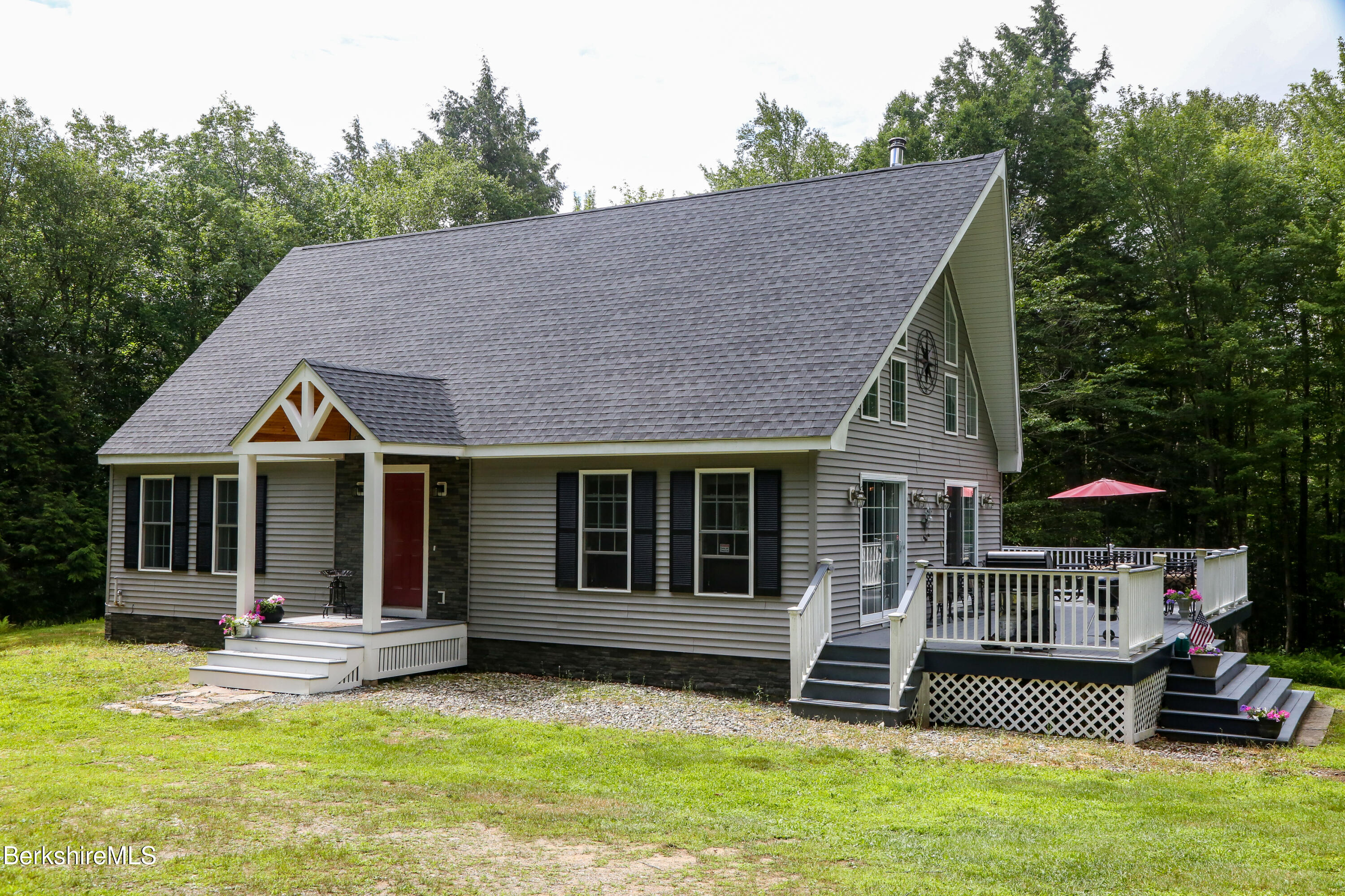 a view of a house with a yard and large tree
