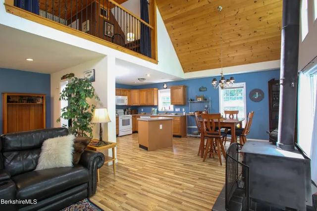 a living room with furniture kitchen view and a wooden floor