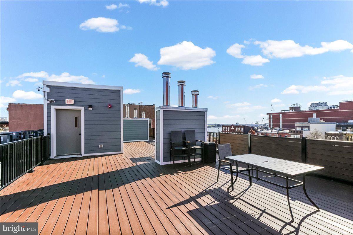 102 Church Street, Unit 402 Philadelphia, PA 19106 - Photo 17 of 24 a view of a roof deck with table and chairs with wooden floor and fence
