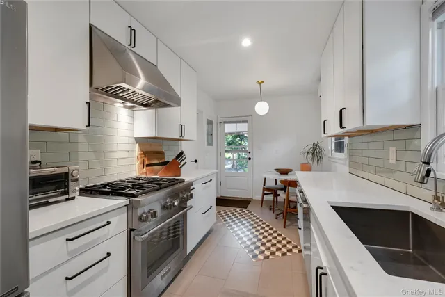 a kitchen with granite countertop a stove and a sink