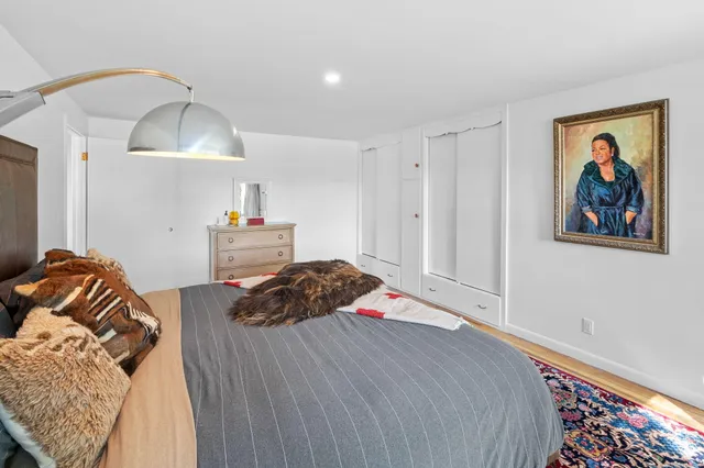 a bedroom with a bed and a painting on the wall