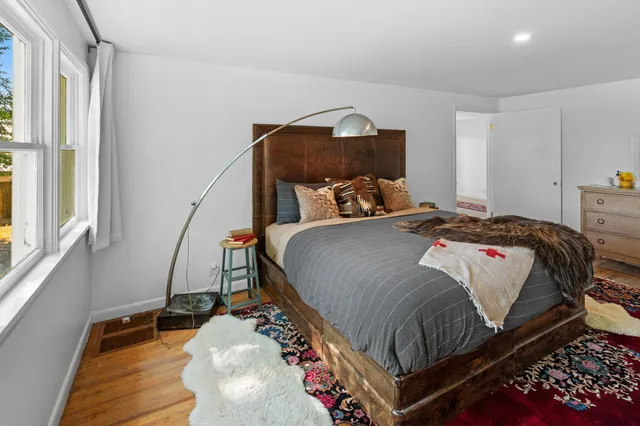 a bedroom with a bed and wooden floor