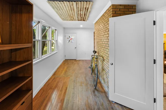a view of a hallway with wooden floor and staircase