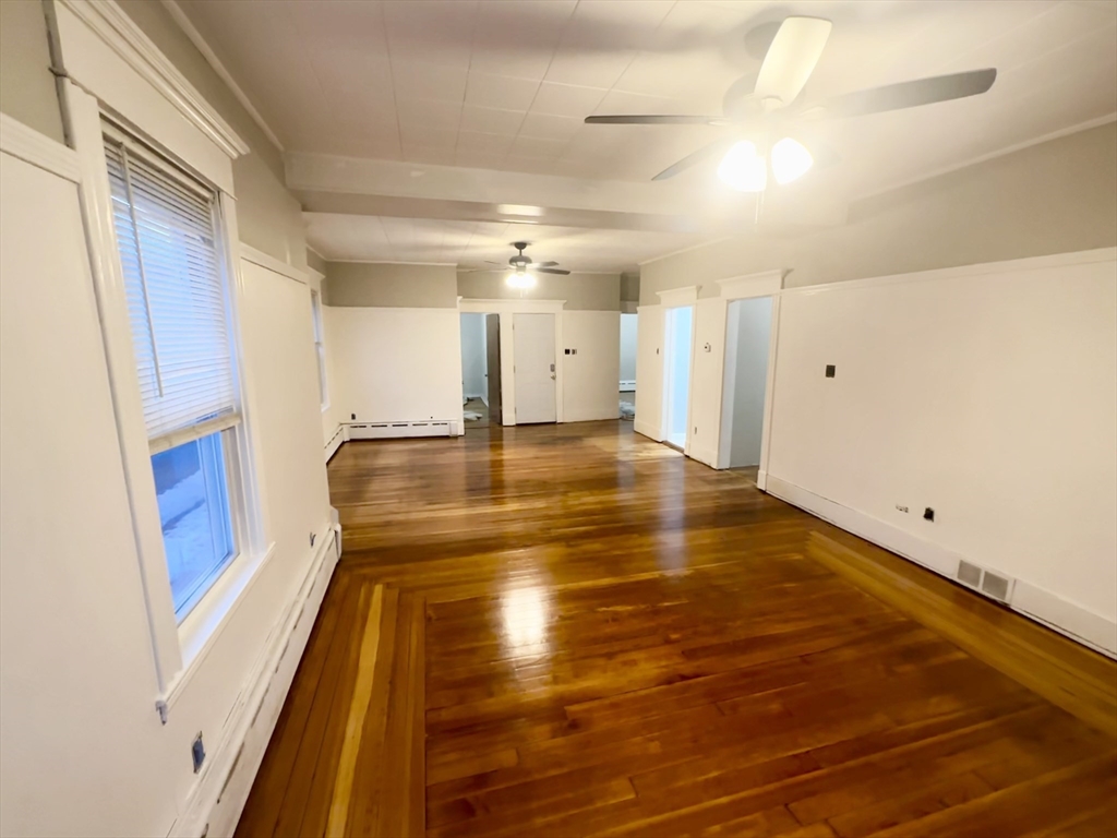 a view of an empty room with wooden floor
