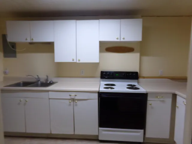 a kitchen with granite countertop a stove and a sink