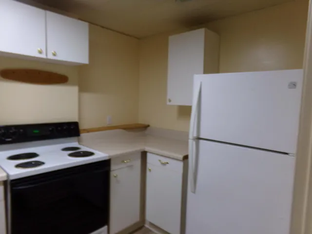 a white refrigerator freezer sitting inside of a kitchen