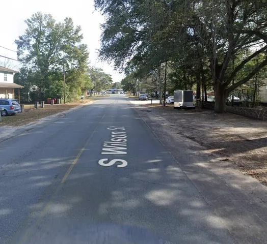 a kitchen with a sink and a stove with wooden floor