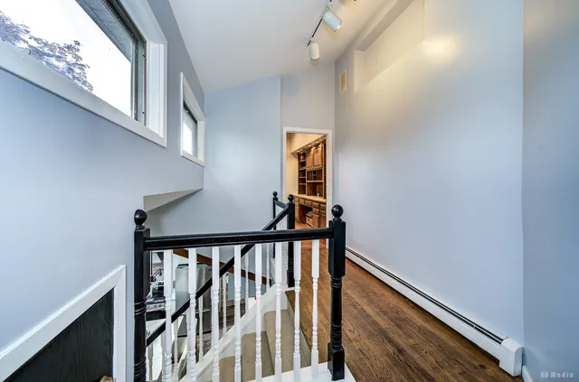 a view of staircase with railing and white walls