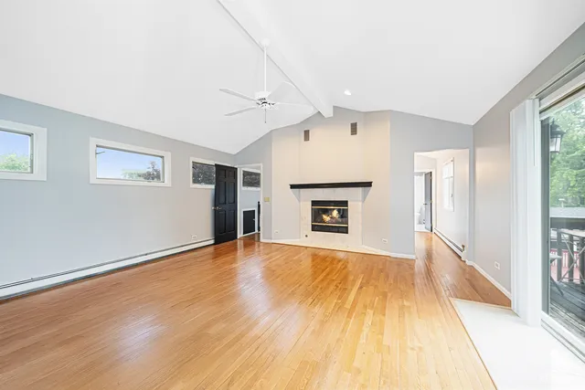 a view of empty room with wooden floor and fireplace