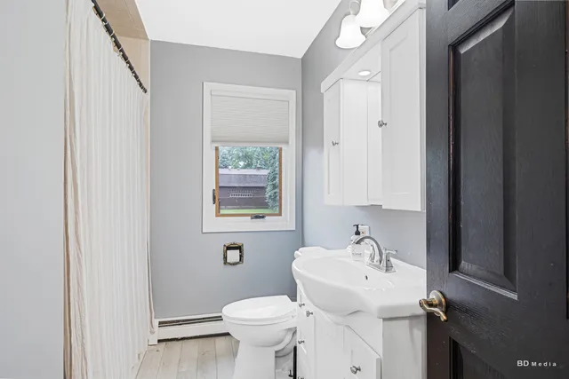 a bathroom with a sink toilet and a mirror