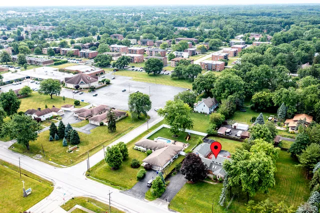 an aerial view of residential houses with outdoor space and trees