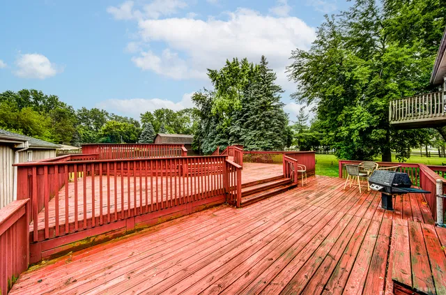 a balcony with wooden floor table and chairs