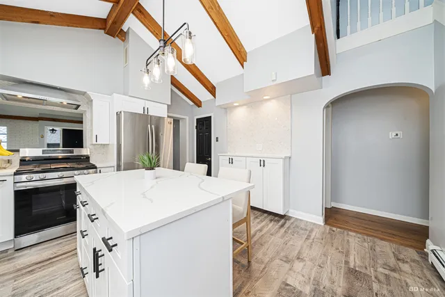 a kitchen that has a sink a stove top oven and white stainless steel appliances