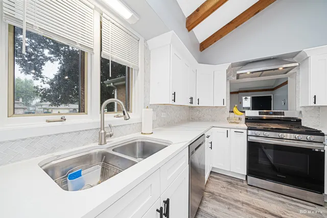 a kitchen with a sink and a stove top oven