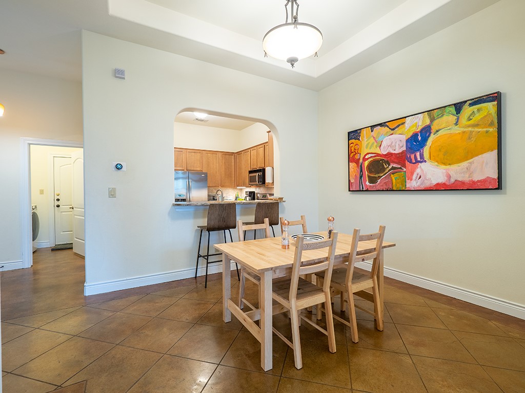 3609 Clawson Road, Unit B Austin, TX 78704 - Photo 11 of 28 Dining area featuring tray ceiling, pendant lighting, and durable tile flooring