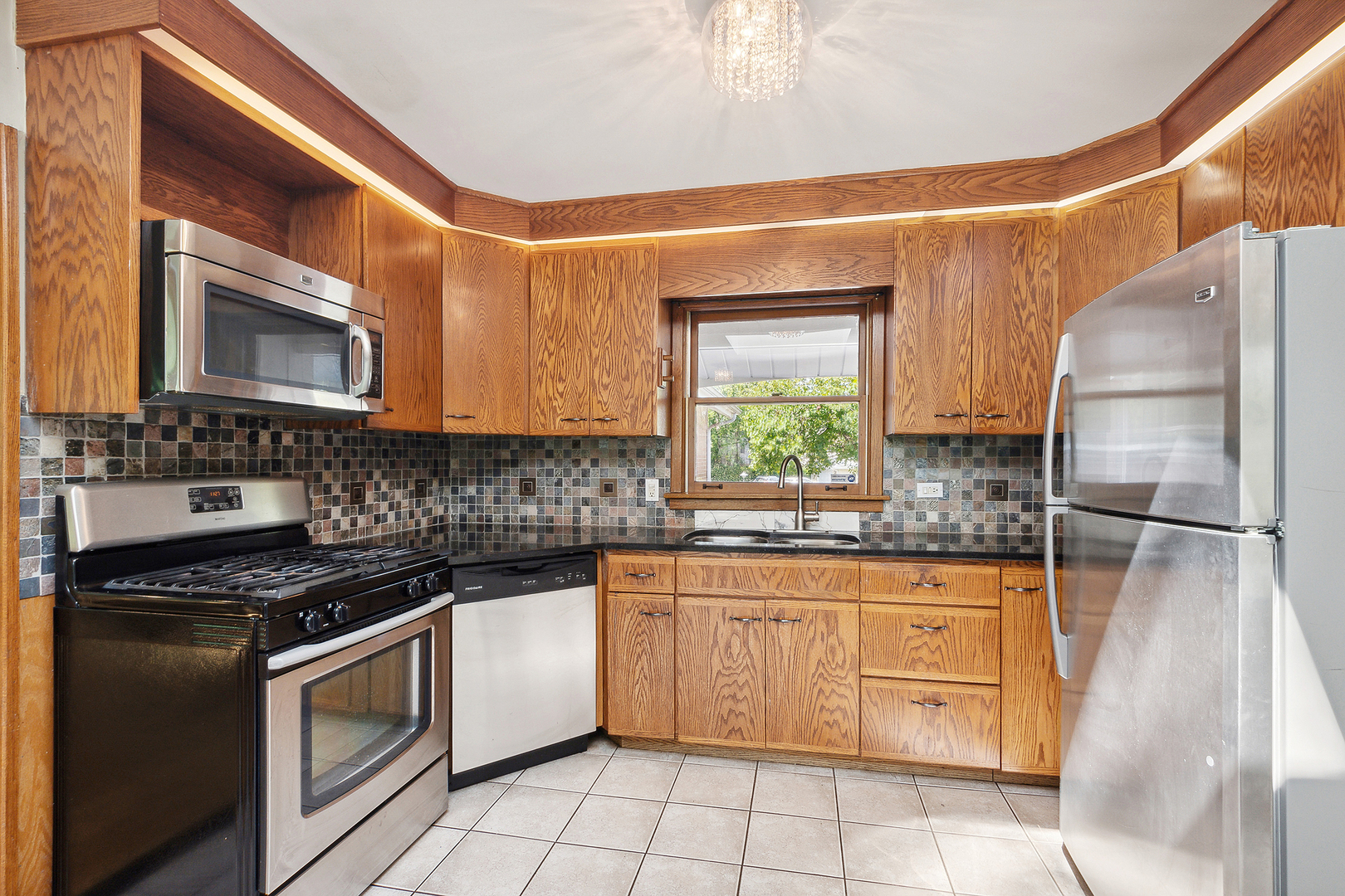 509 Hawthorne Road Frankfort, IL 60423 - Photo 13 of 36 a kitchen with stainless steel appliances granite countertop a stove a sink and a microwave