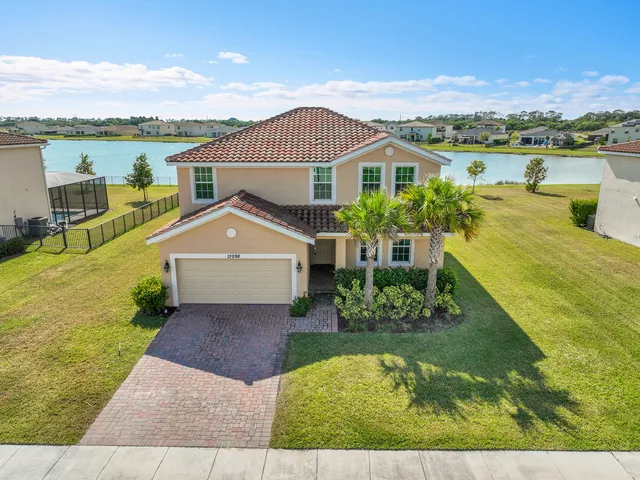 an aerial view of a house with pool and a lake view