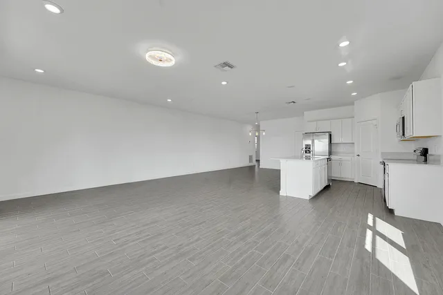 a kitchen with granite countertop a sink stainless steel appliances and white cabinets