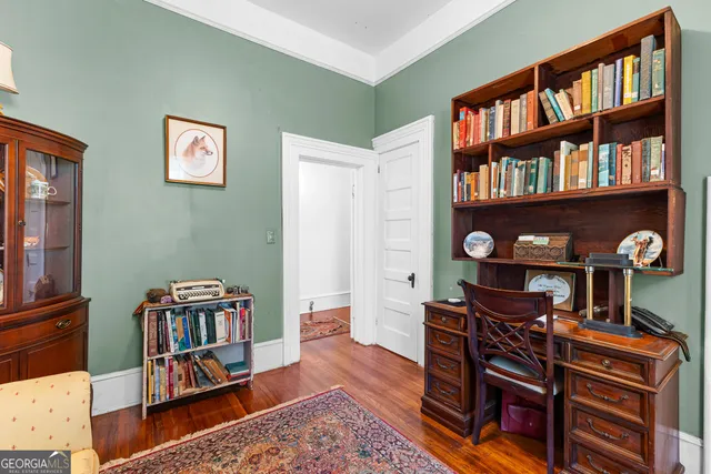 a view of a hallway with wooden floor and windows
