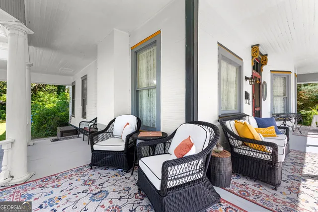 a living room with furniture floor to ceiling window and wooden floor