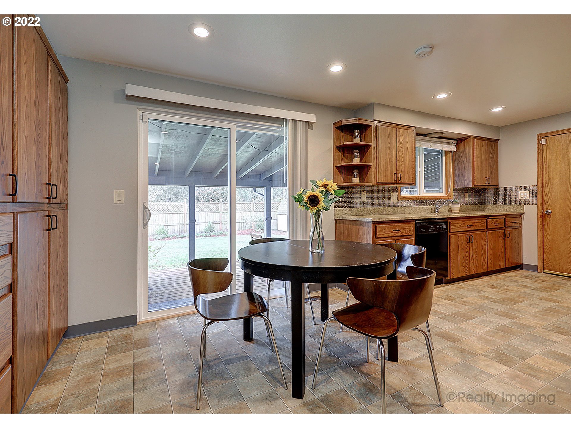13936 Southeast Taylor Street Portland, OR 97233 - Photo 6 of 24 a open dining room with stainless steel appliances kitchen island granite countertop a table chairs and a refrigerator