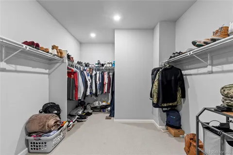 a view of walk in closet with clothes and shoes
