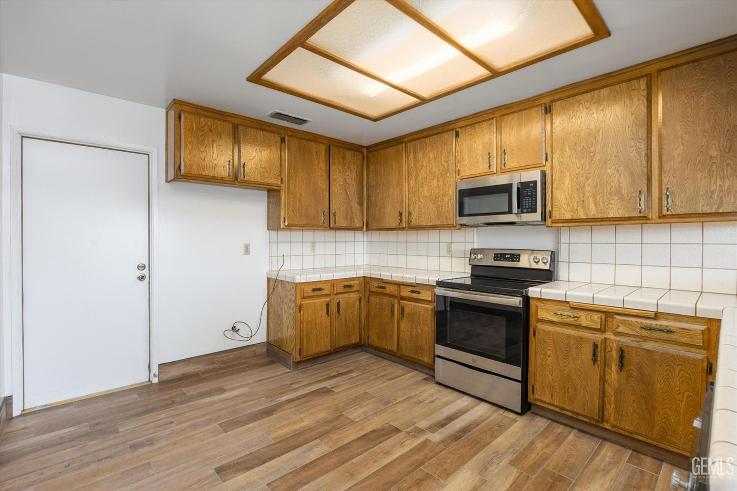 Undisclosed Address Bakersfield, CA 93308 - Photo 15 of 37 a kitchen with stainless steel appliances granite countertop a stove a sink and a microwave
