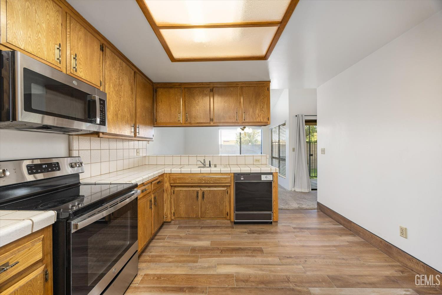 Undisclosed Address Bakersfield, CA 93308 - Photo 18 of 37 a kitchen with stainless steel appliances granite countertop a stove a sink and a microwave