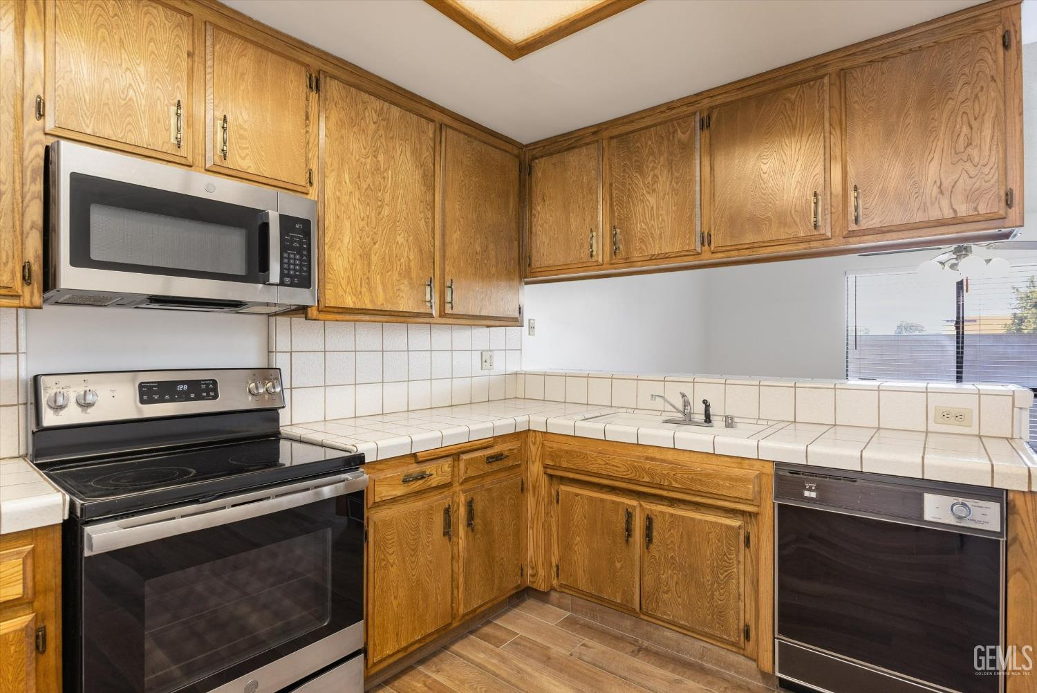 Undisclosed Address Bakersfield, CA 93308 - Photo 19 of 37 a kitchen with stainless steel appliances granite countertop a sink stove and microwave