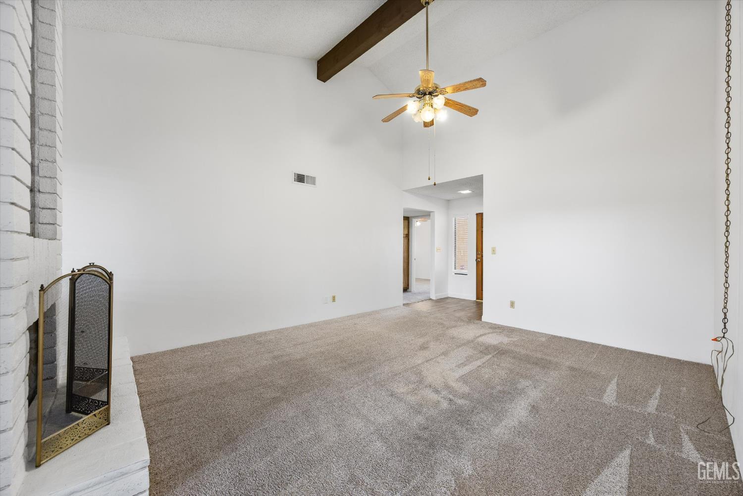 Undisclosed Address Bakersfield, CA 93308 - Photo 10 of 37 an empty room with a chandelier fan and wooden floor