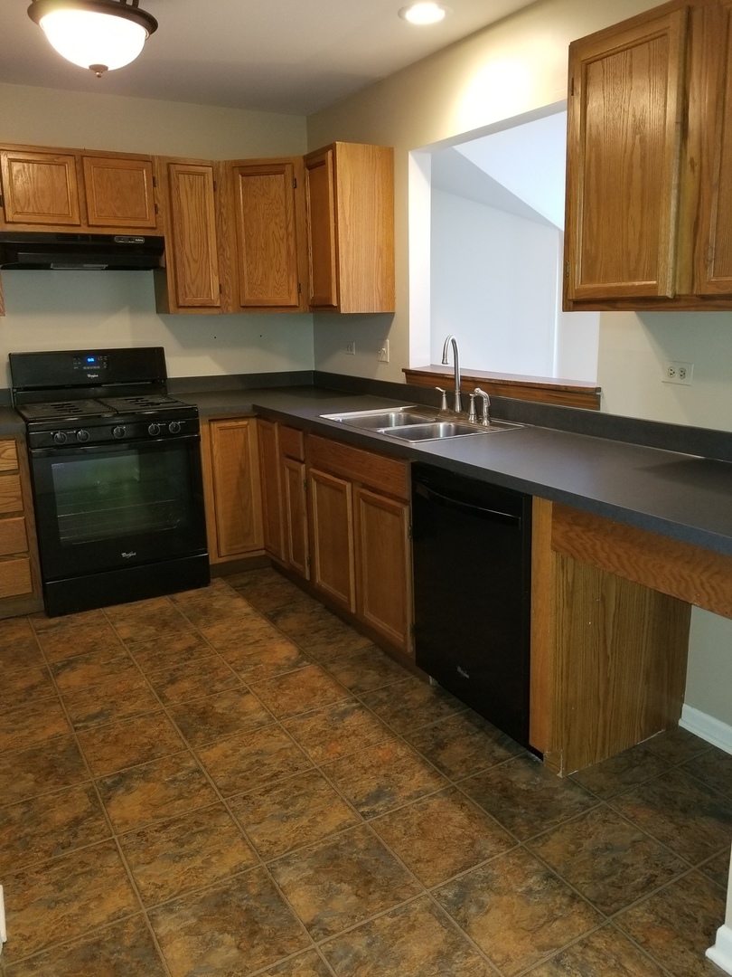 1280 Rhodes Lane, Unit 1280 Naperville, IL 60540 - Photo 7 of 11 a kitchen with granite countertop a sink and cabinets
